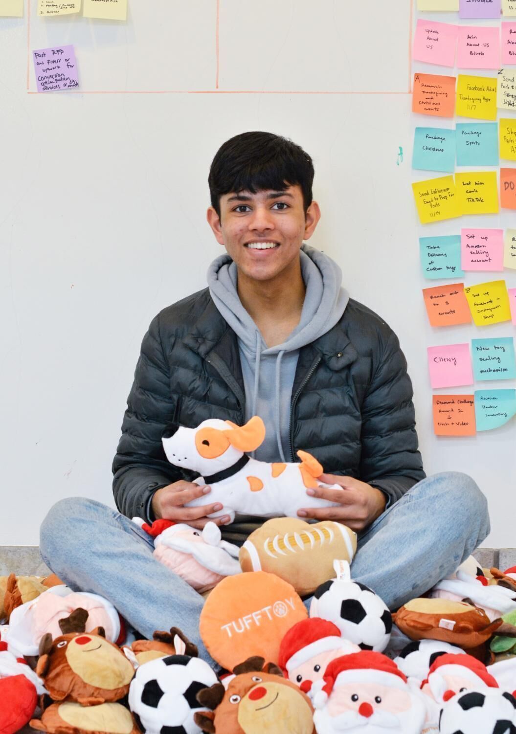 Arin Jain surrounded by TuffToy products with a business planning whiteboard behind him